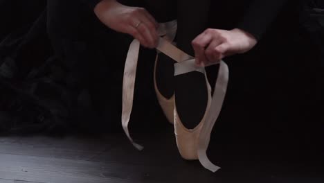 ballerina tying her pointe shoes