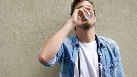 young man having coffee from disposable cup