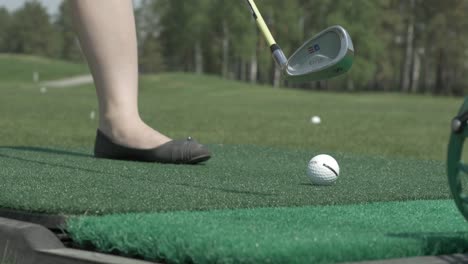 woman practicing golf swing on driving range