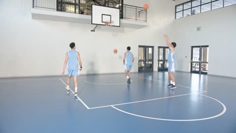 basketball players practicing passing drills on indoor court, focused and determined