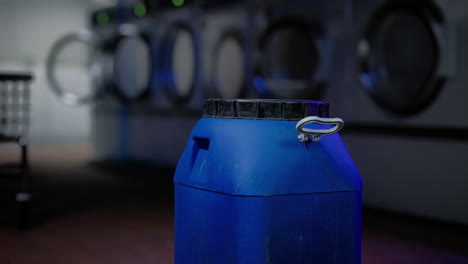 a blue container of laundry detergent sitting in a laundromat