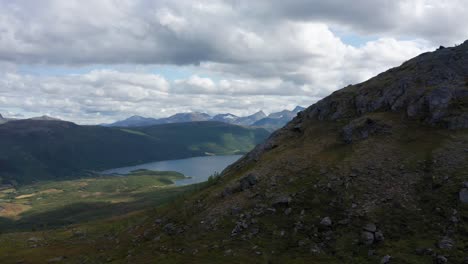 Toma-De-Drones-Del-Paisaje-Del-Norte-De-Noruega-Con-Montañas,-Lagos-Y-Fiordos-Y-Cielo-Dramático