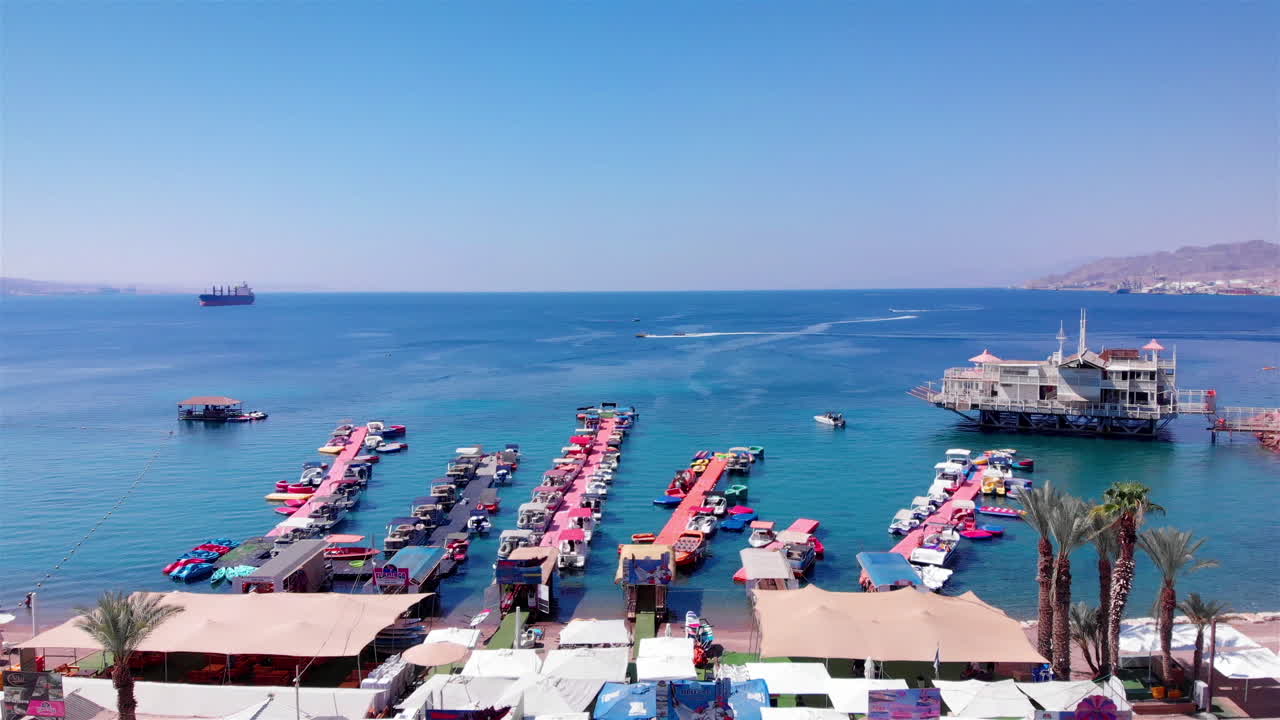 Aerial Footage over Deck Marina With Speed boats Desert mountains and blue sea