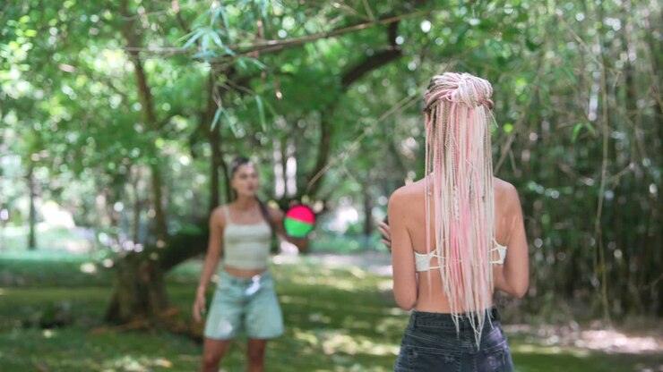Two women playing catch in the park