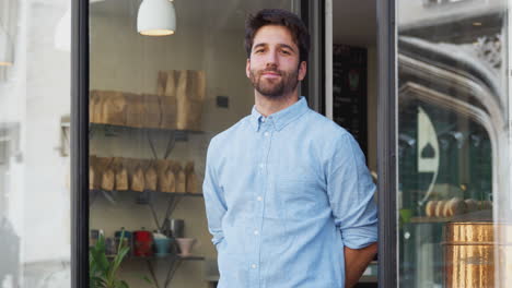 Portrait-Of-Male-Owner-Standing-Outside-Coffee-Shop