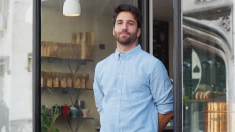 retrato del propietario masculino de pie fuera de la cafetería