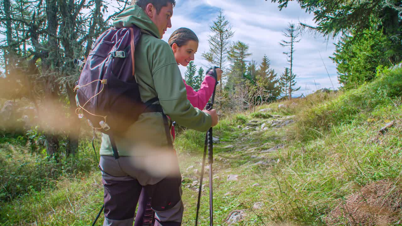 Una joven pareja de excursionistas hace una pausa para admirar la naturaleza en una ruta de senderismo