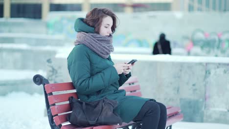 woman using phone in winter park