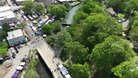aerial track backwards reveals dogwood festival booths and stalls during sunny day in siloam springs - hyperlapse