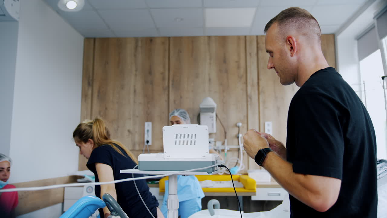 Caucasian couple preparing for the labor. Woman stands at the bed talking to medics and man stands beside worrying.