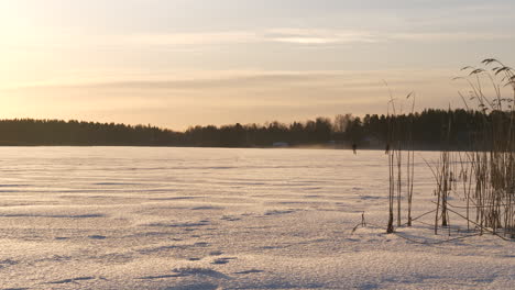 Silueta-De-Dos-Patinadores-Sobre-Hielo-En-Un-Lago-De-Invierno-Congelado,-Tiro-Deslizante