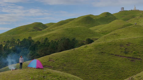 un excursionista se despierta en un hermoso paisaje en sailung, dolakha, nepal, cerca del tíbet sentado junto a una hoguera por la mañana, disfruta de su pacífico viaje en solitario en medio de la exuberante vegetación y la naturaleza serena
