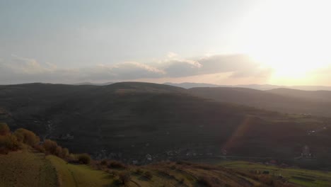 Aerial-shot-passing-over-a-hill-and-revealing-the-village