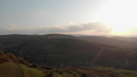 aerial shot passing over a hill and revealing the village