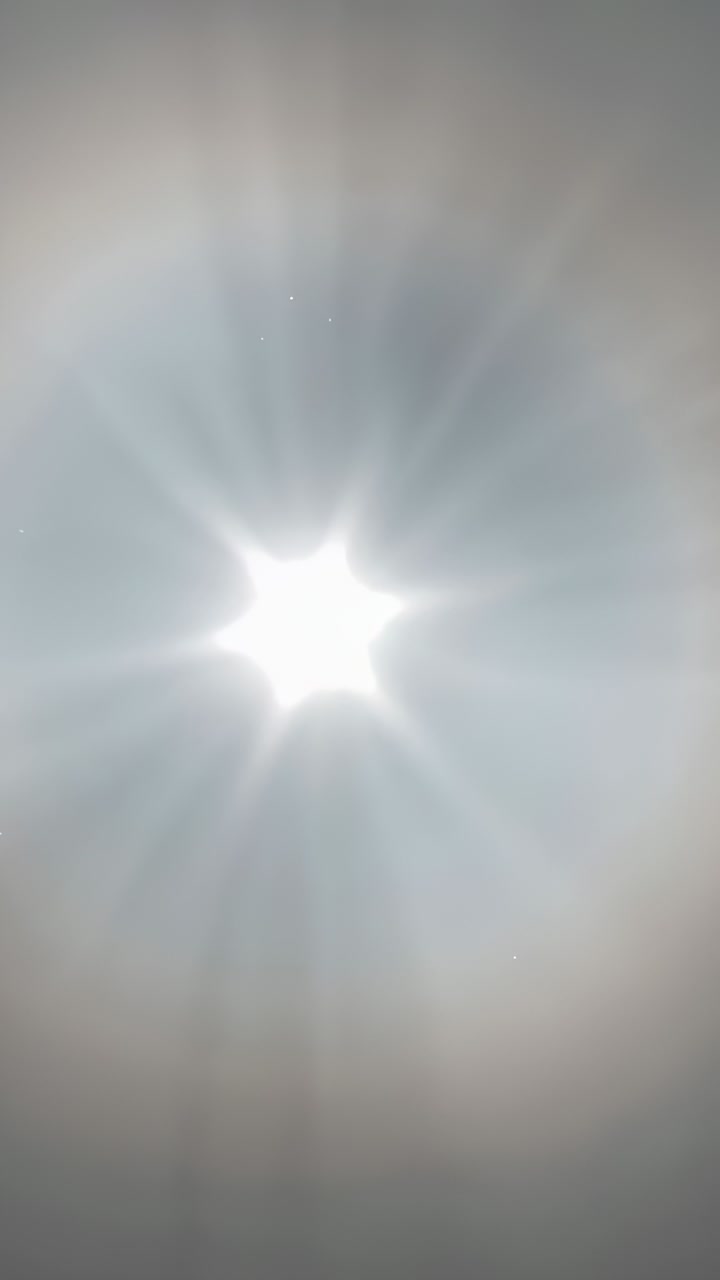 Vertical video: Recording phone adjusting exposure while pointing at ceiling ring, showing flare