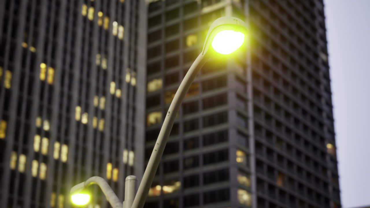 City lights glow softly in the evening as dusk descends on urban buildings