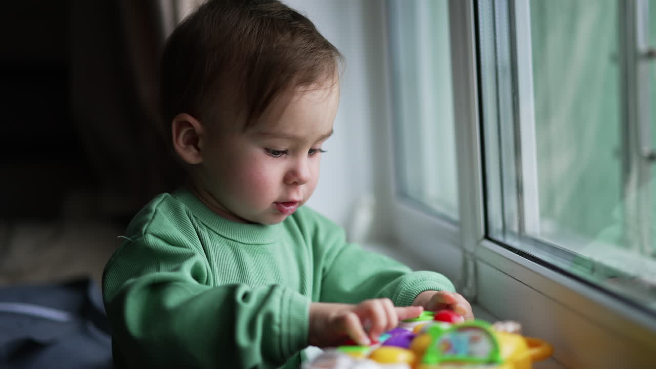 Bambino che gioca con un giocattolo vicino alla finestra