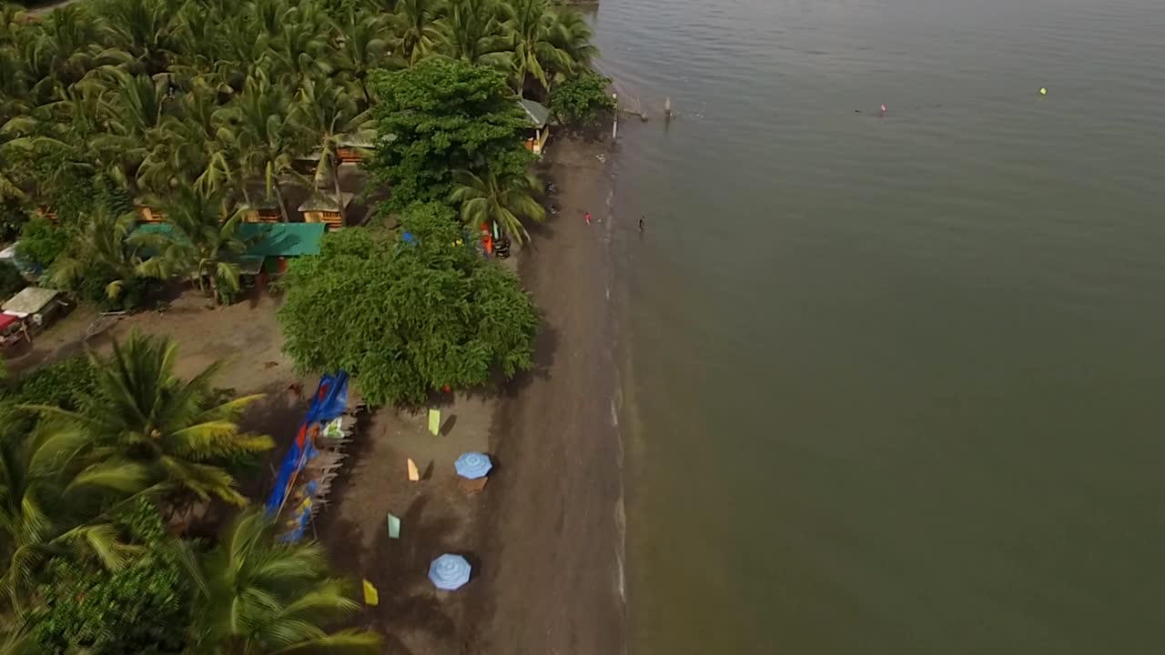 casas y establecimientos de asentamiento en la playa de arena y hermoso mar tranquilo en un día nublado, avión no tripulado aéreo
