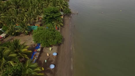 settlement houses and establishments on sandy beach and beautiful calm sea on cloudy day, drone aerial