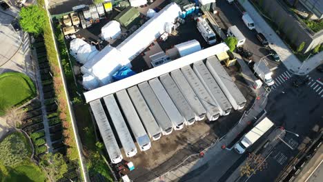an aerial view over temporary morgue refrigeration trailers containing the bodies of victims of the coronavirus pandemic 2