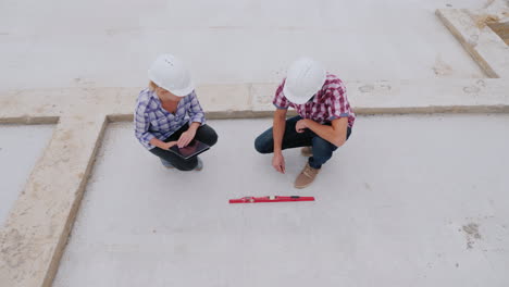 los ingenieros verifican la precisión de la construcción de edificios usan el nivel y el video de la tableta 4k