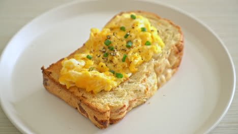 bread-toast-with-scramble-egg-on-white-plate