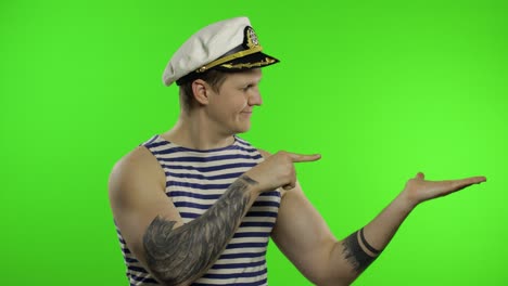 young sailor man shows something with hands. seaman guy in sailor's vest