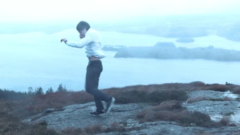 an energetic young man dancing in the rain runs out of frame