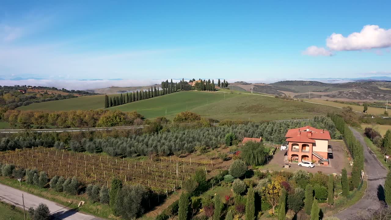 hermoso paisaje de la toscana en italia - casa de campo, cipreses a lo largo de la carretera blanca - vista aérea de drones