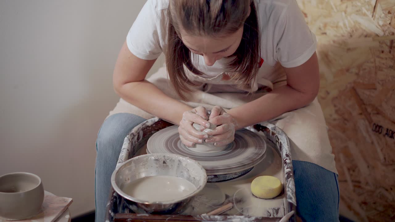 женщина формирует глину на керамическом колесе