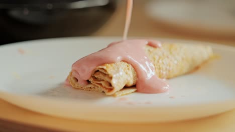close up, soft crepe being covered with homemade creamy banana strawberry blend