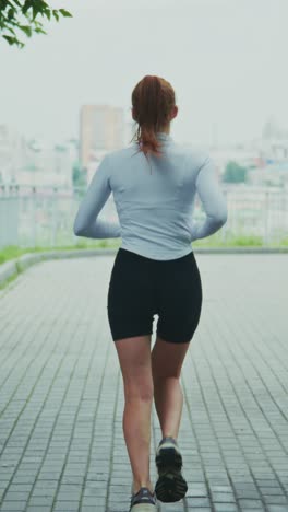 a dedicated runner in activewear enjoys the outdoors while jogging along a scenic pathway, embracing the fresh air and urban landscape