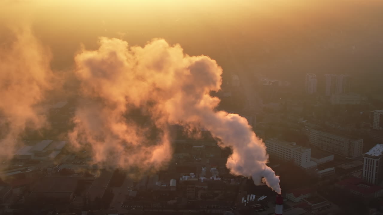 Aerial drone view of thermal power plant in Chisinau at sunrise, Moldova. View of pipe with felling steam, cityscape