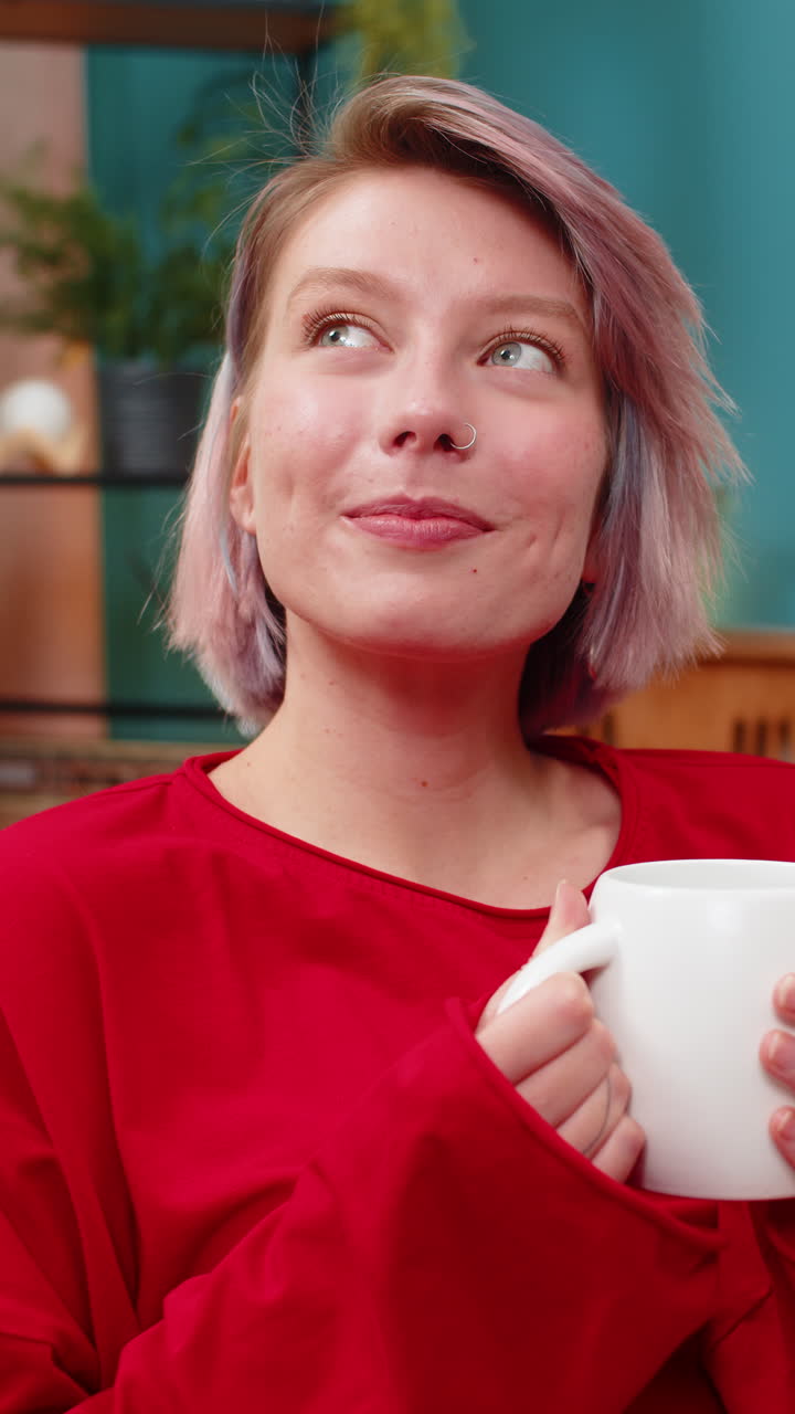 Woman enjoying drinking coffee sits comfortably on couch relaxed satisfied calm leisure expression