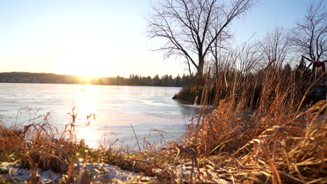 Toma-Panorámica-De-Un-Lago-Congelado-En-Invierno-Al-Atardecer