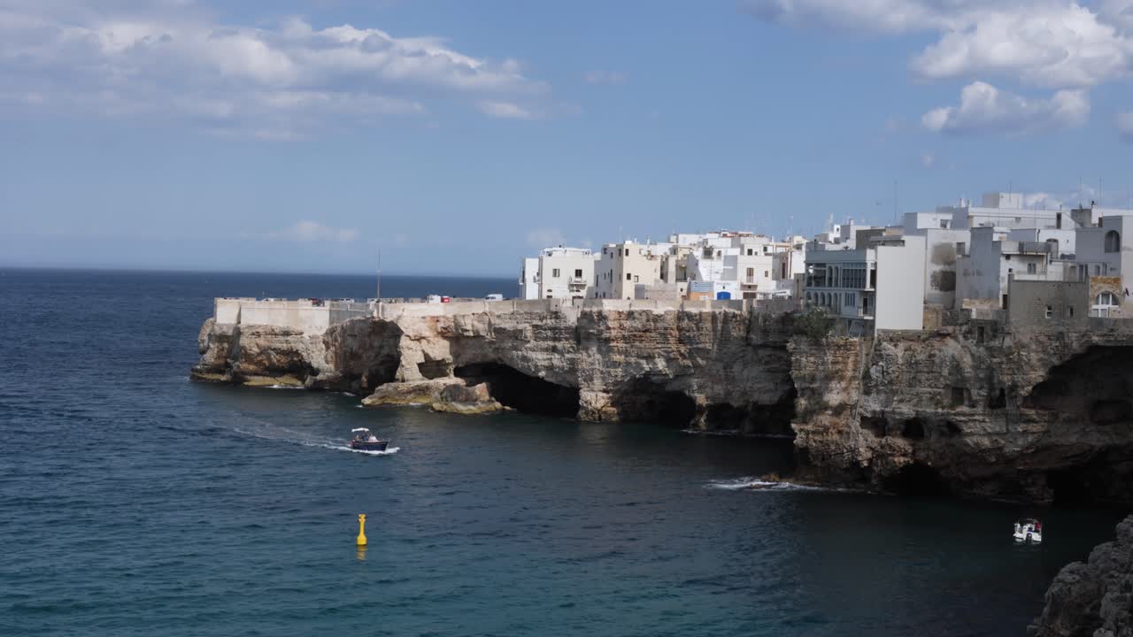 Tourist boat tour drive near rocky picturesque coast of Polignano a mare