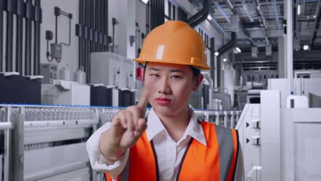 close up of asian female engineer with safety helmet disapproving with no index finger sign with water production in bottling factory