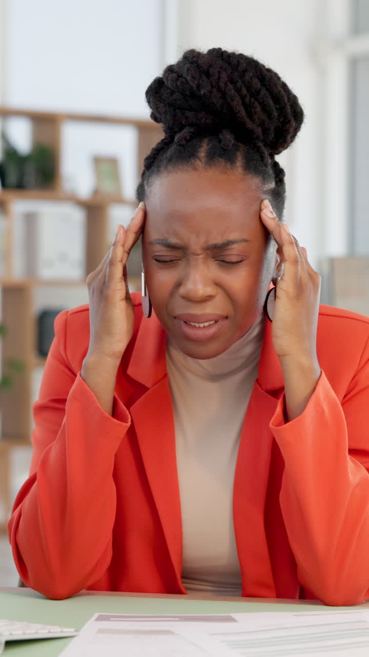 Stressed Businesswoman Suffering from a Headache in the Office