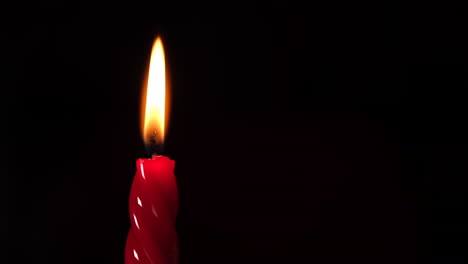 red candle light on black background