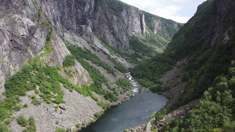 spectacular aerial in remote valley maboedalen valley leading up to hardangervidda national park - road rv7 beside freshwater lake with river and steep hillsides - norway