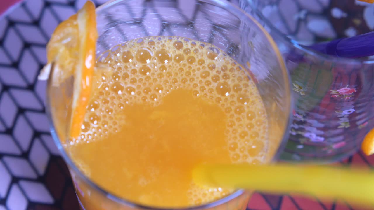 vertiendo jugo de naranja fresco en un vaso