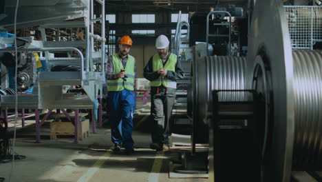 trabajadores de la fábrica inspeccionando la maquinaria