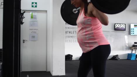 Aufnahmen-Eines-Schwangeren-Weiblichen-Models,-Das-In-Einem-Fitnessstudio-Kniebeugen-Macht-Und-Versucht,-Sich-In-Ihrem-Vierten-Trimester-Fit-Zu-Halten