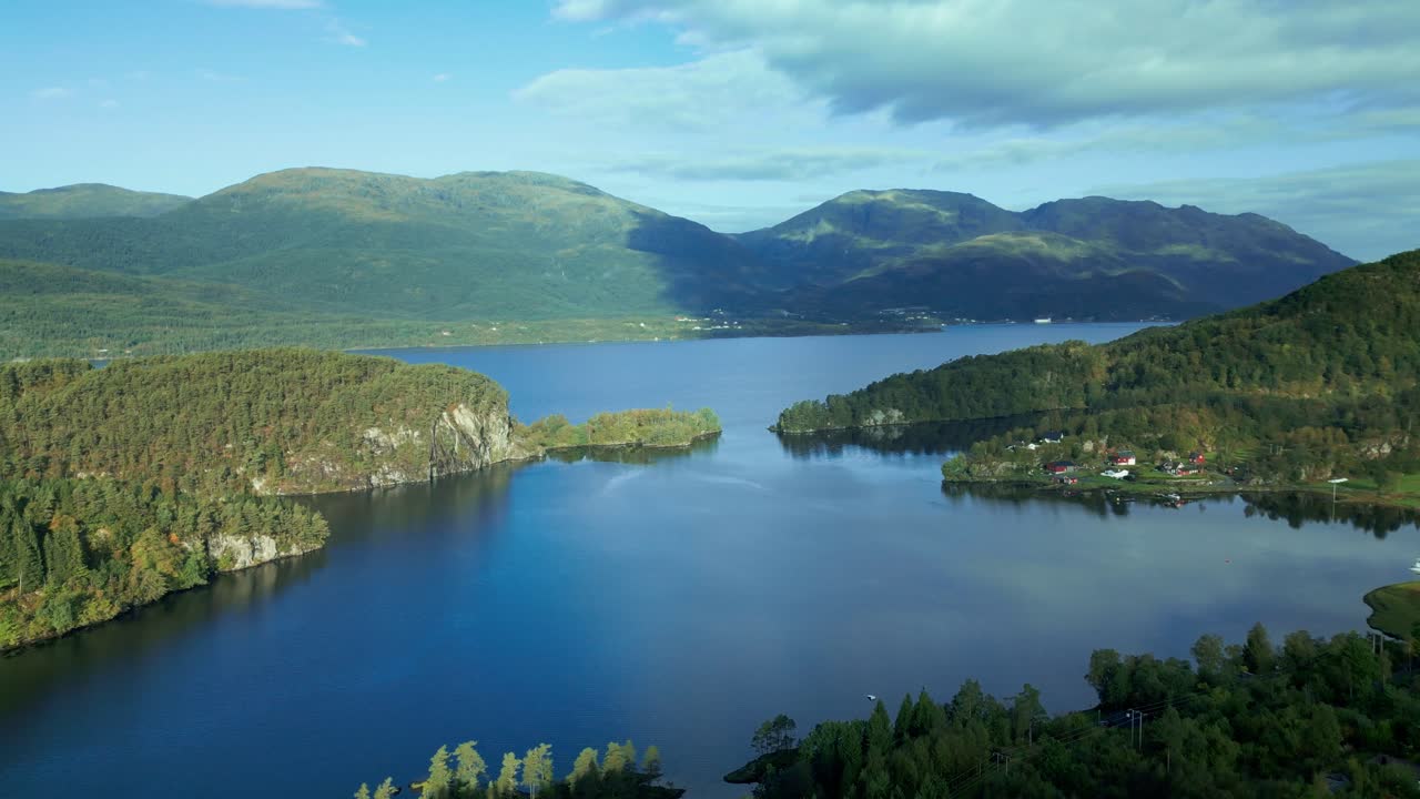 Drone over Norway's fjords on a sunny and cloudy day with Mountains in the background