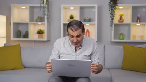 hombre mirando la computadora portátil con asombro.
