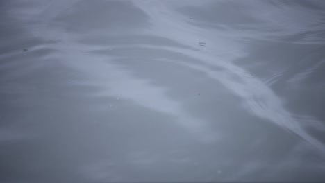 a slow motion of rain drop in the water the pond rainy day closeup