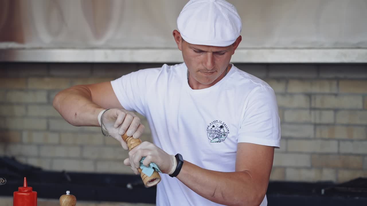 Focused chef cooking food. Portrait of chef salting food at restaurant