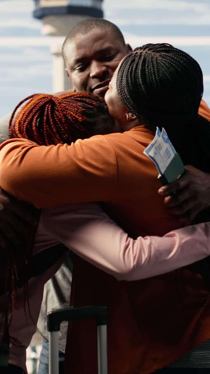 African Family Hugging at Airport During Emotional Reunion