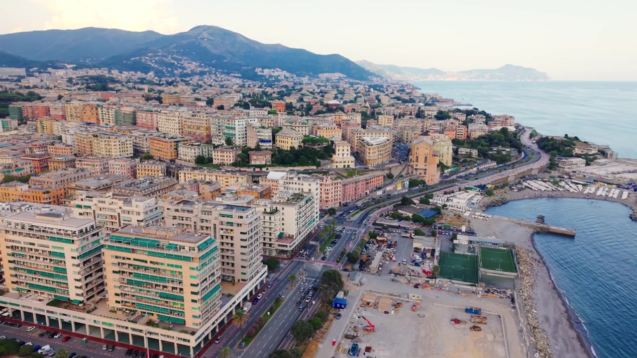 Vista aerea della costa di Genova con edifici colorati, strade e il Mar Ligure