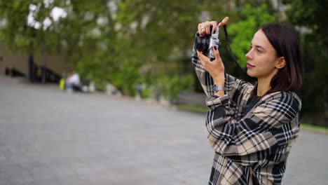 a young woman taking pictures with a camera in a city